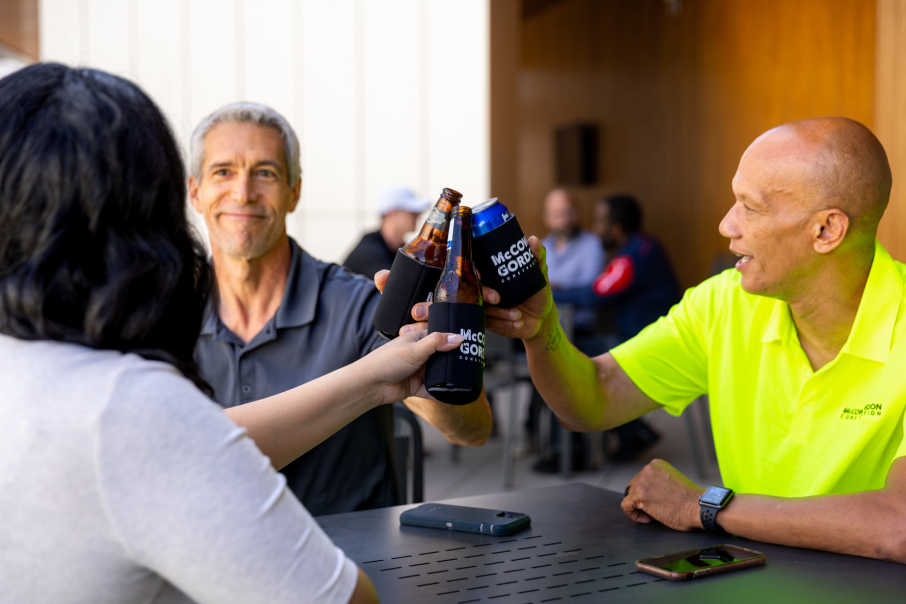 Three McCownGordon Construction associates drinking together on the rooftop at the office