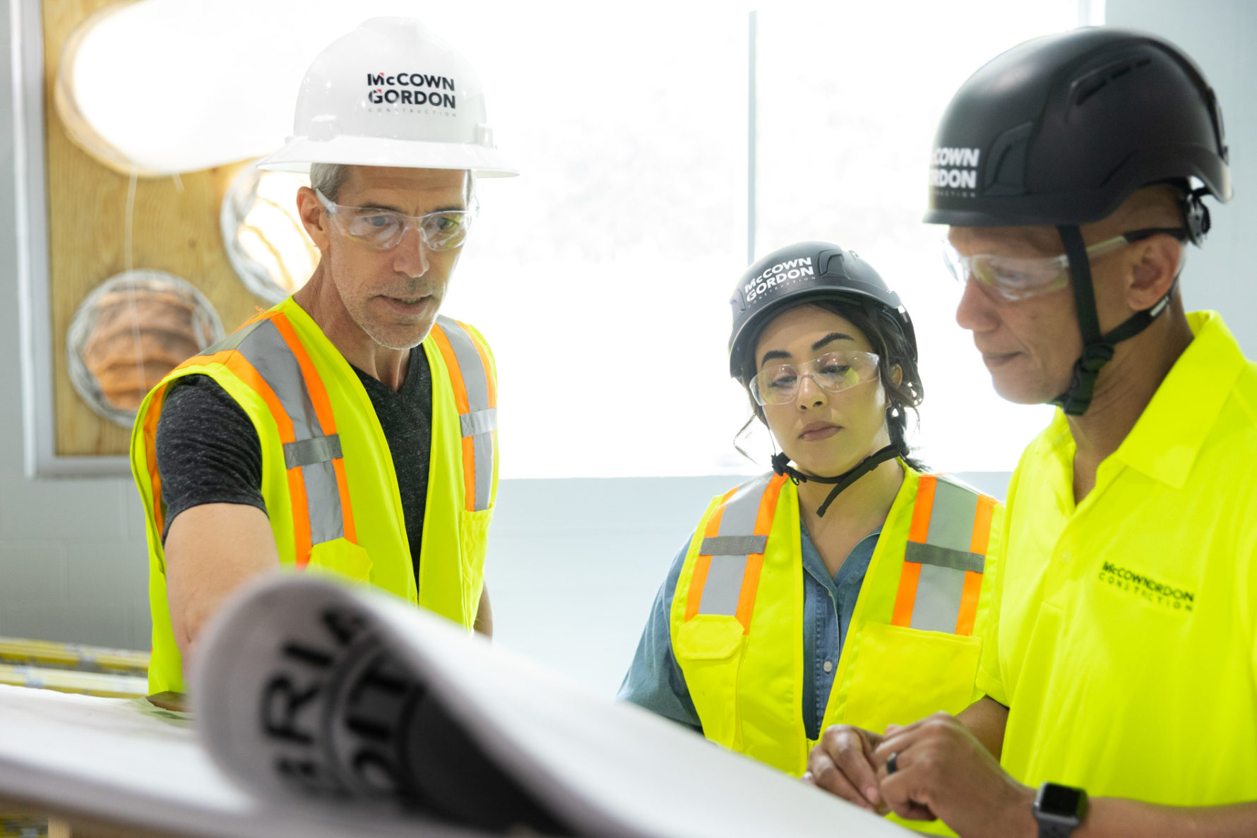 Three McCownGordon associates looking at construction drawings together