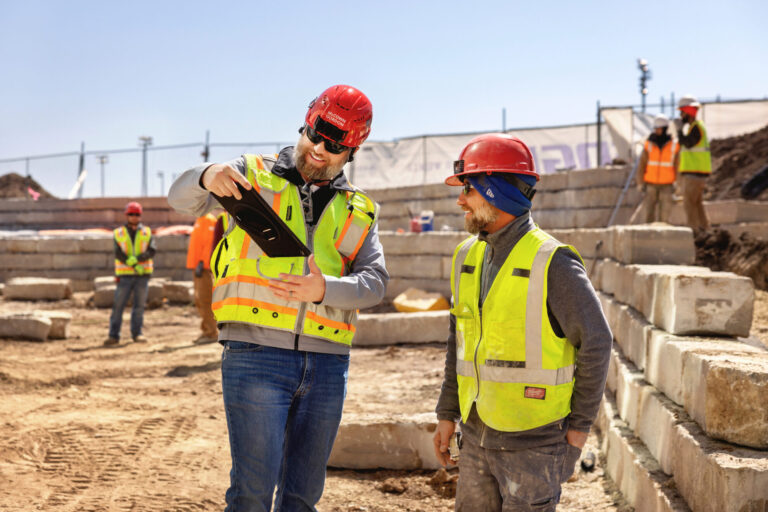 Two McCownGordon associates talking and looking at an ipad on a construction jobsite