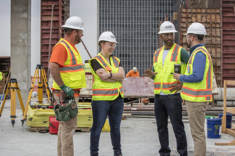 Four McCownGordon Construction associates talking on a construction site