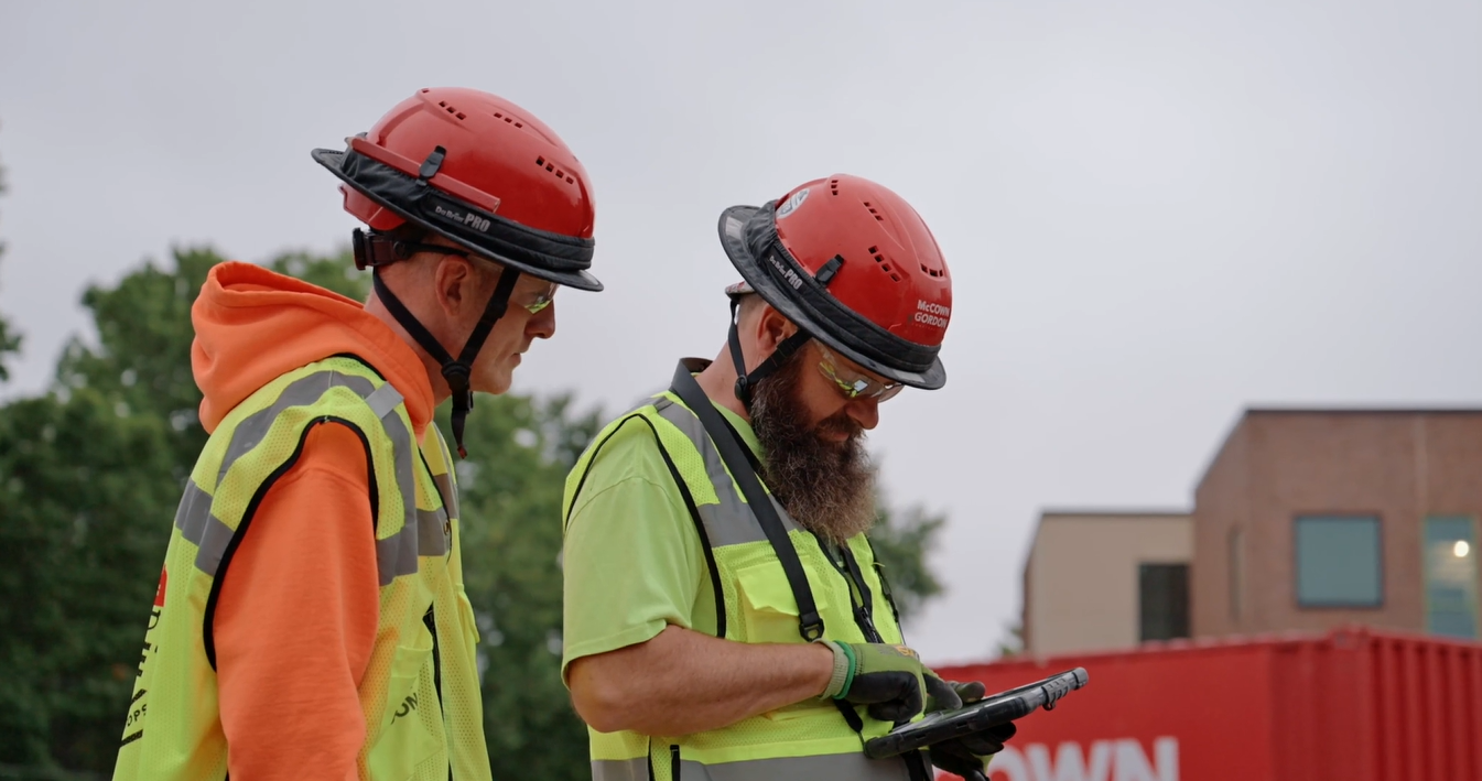 Two McCownGordon COnstruction associates chatting and looking at an ipad on a job site