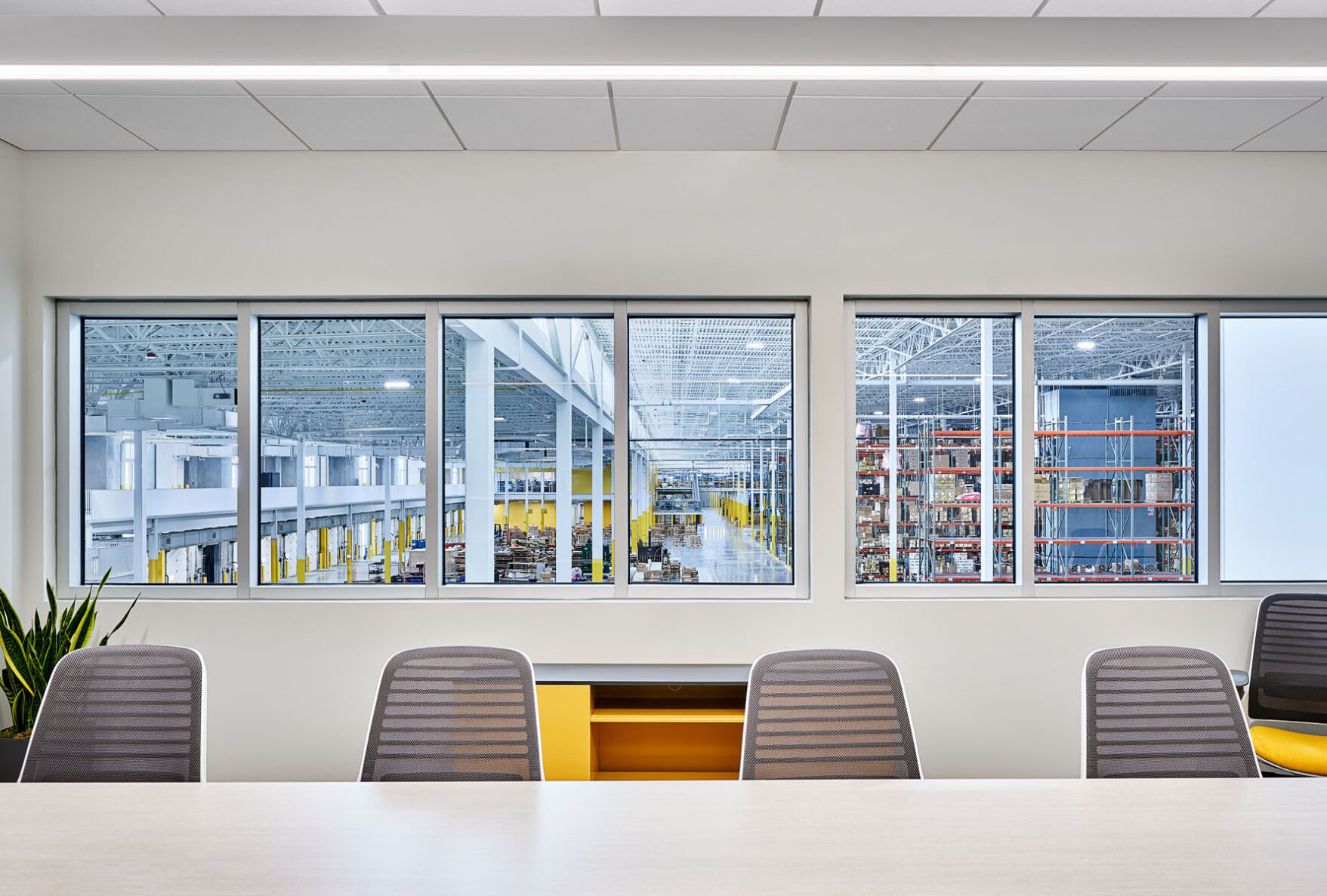 conference room that looks out into a manufacturing production space