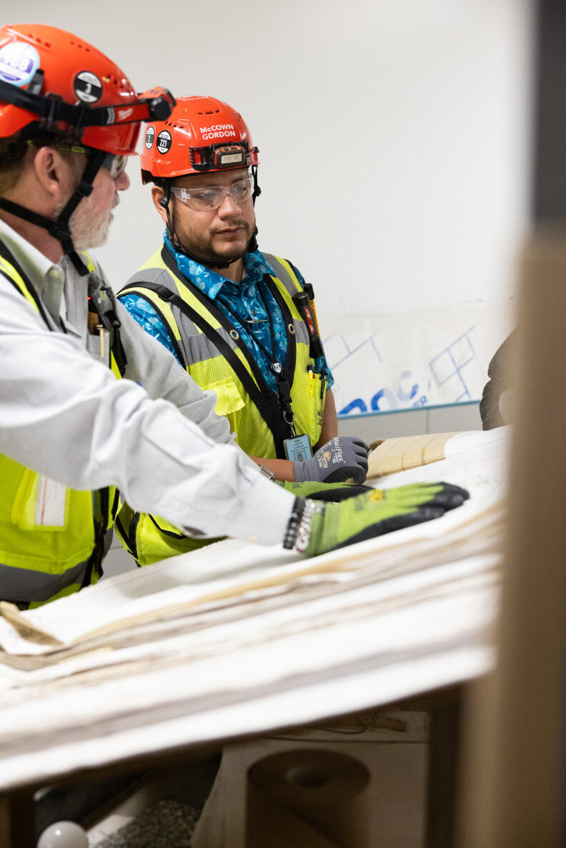 McCownGordon construction workers looking at site plans inside.