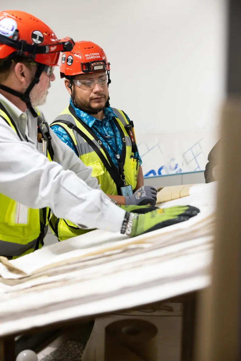 McCownGordon construction workers looking at site plans inside.