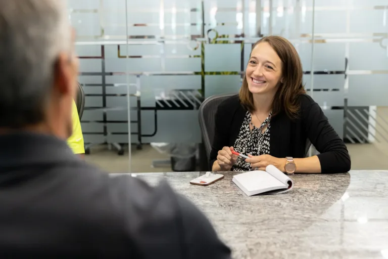 McCownGordon associate smiling and taking notes during a meeting.
