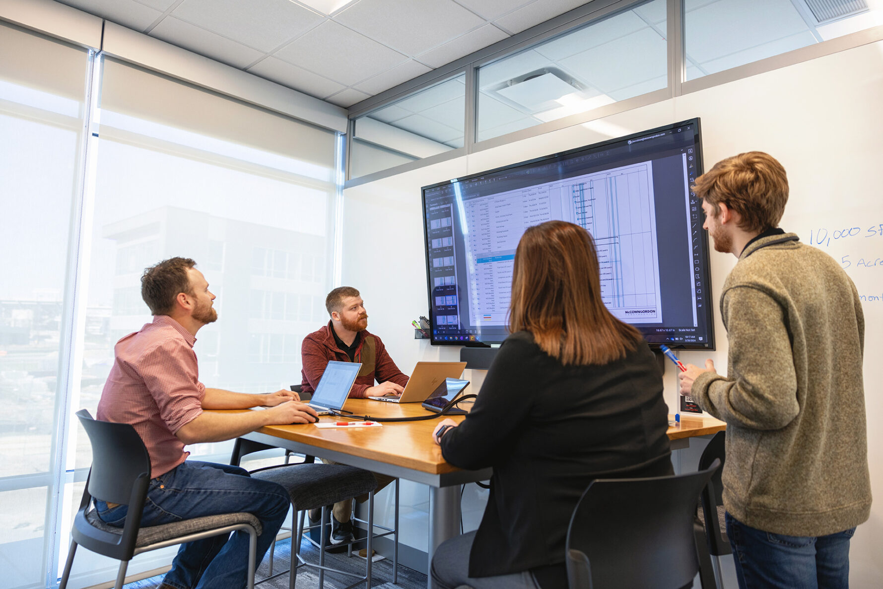 McCownGordon associates looking at a screen together during a construction meeting.